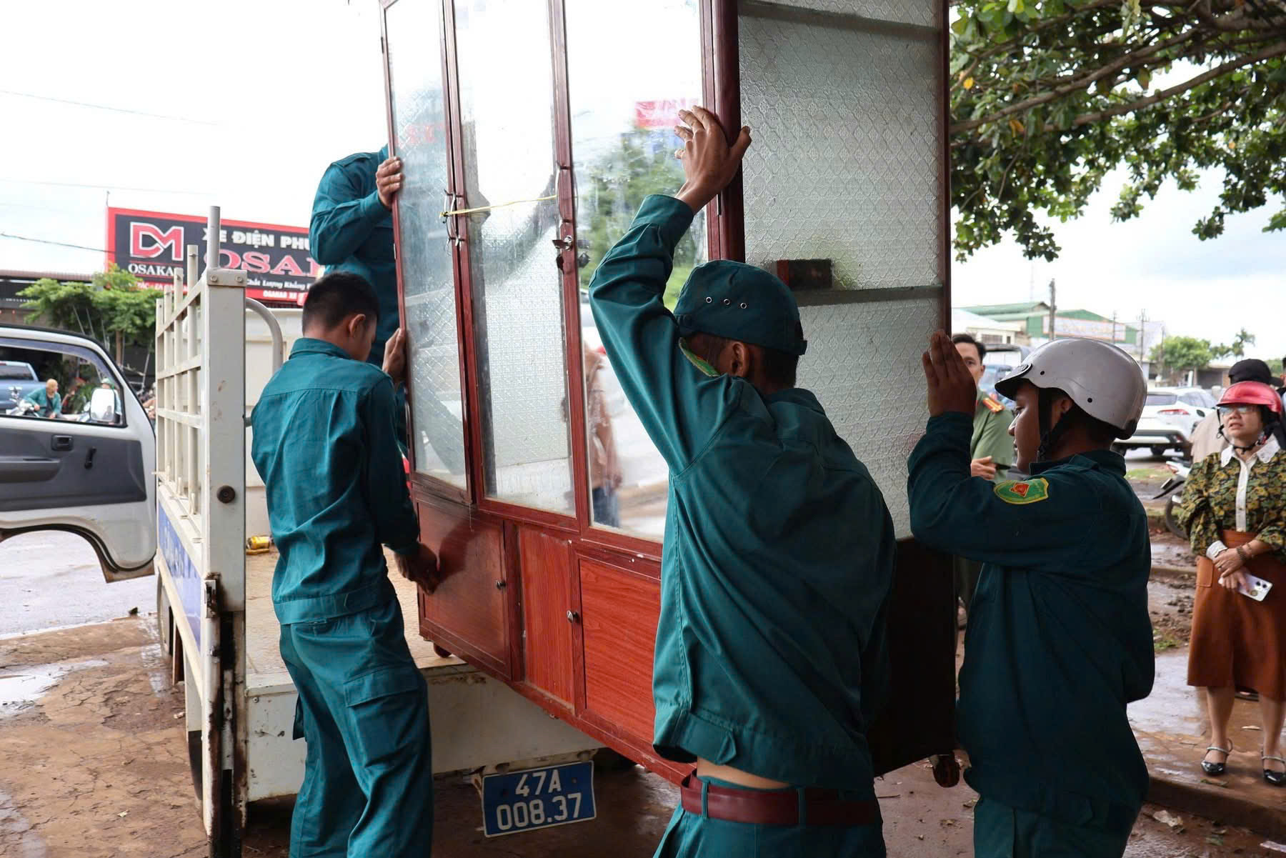 Công an xã và Ban chỉ huy quân sự xã hỗ trợ giúp dân di dời tài sản, vật dụng bàn giao lại mặt bằng hành lang ATGT trên dọc tuyến Quốc lộ 26
